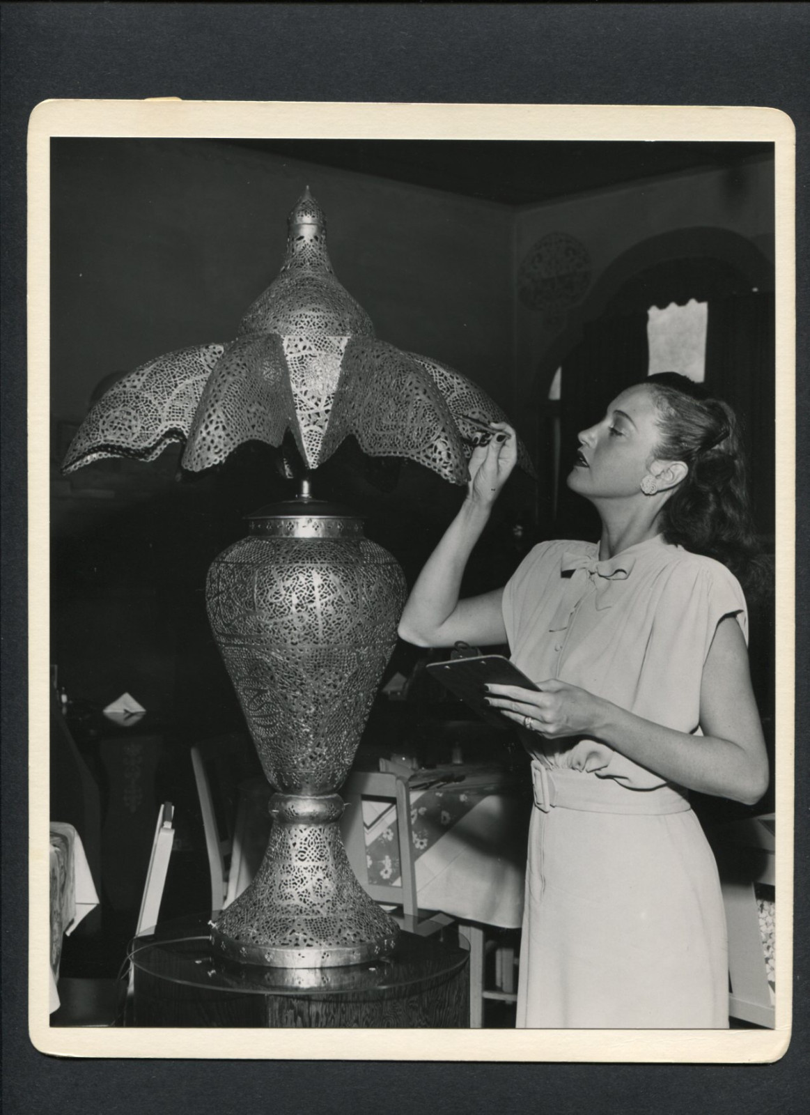 DOROTHY LAMOUR EXAMINES A LAMP -1940s CANDID BY JOSEPH JASGUR – HIS COLLECTION