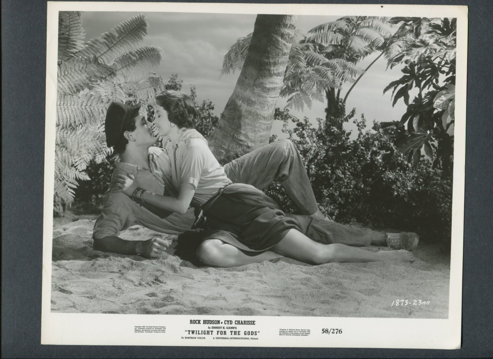 ROCK HUDSON + CYD CHARISSE IN ROMANTIC EMBRACE ON TROPICAL ISLAND – 1958