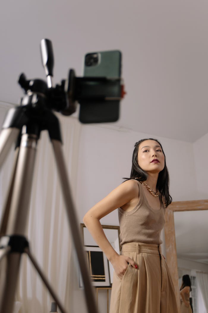 gallery-4 Fashionable Asian woman posing for a vlog indoors, capturing a stylish moment.